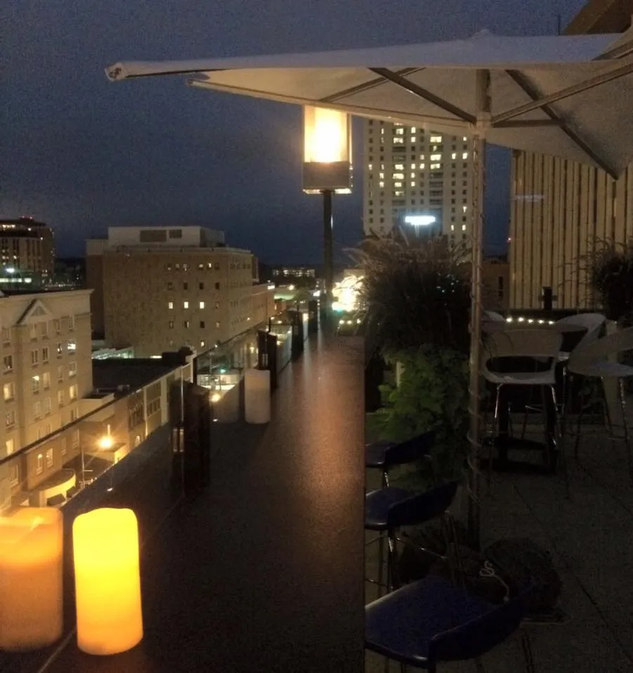 Candles along the La Vetta bar edge at night, the street lit seven floors below