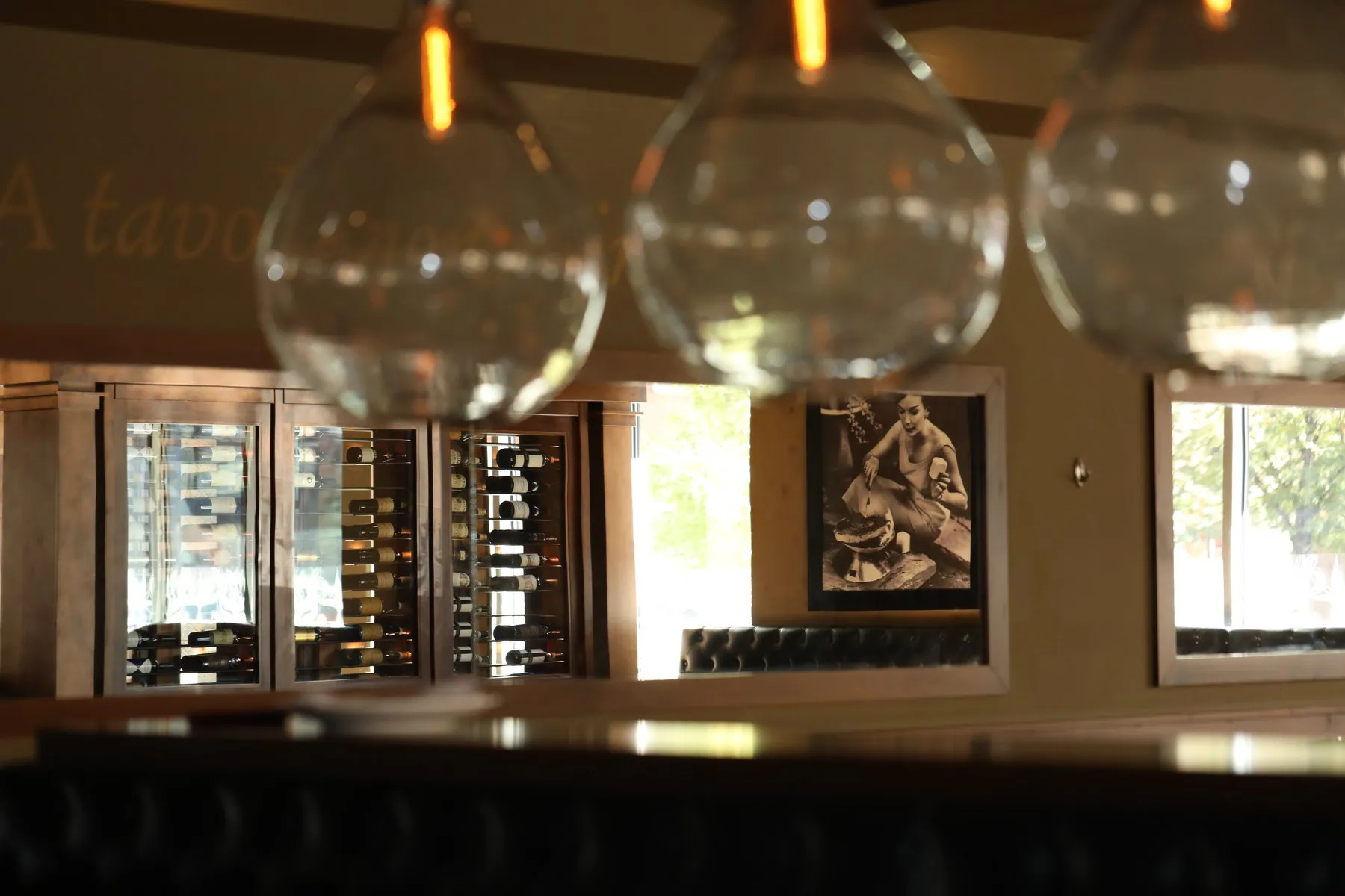 Glass globe pendants over the bar, the wine wall behind