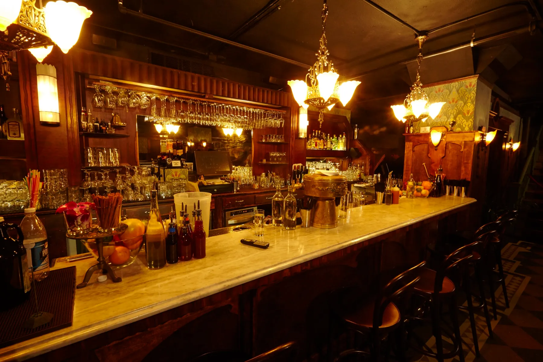 The Volstead’s bar: marble top, hanging glassware, brass fixtures and low lamplight