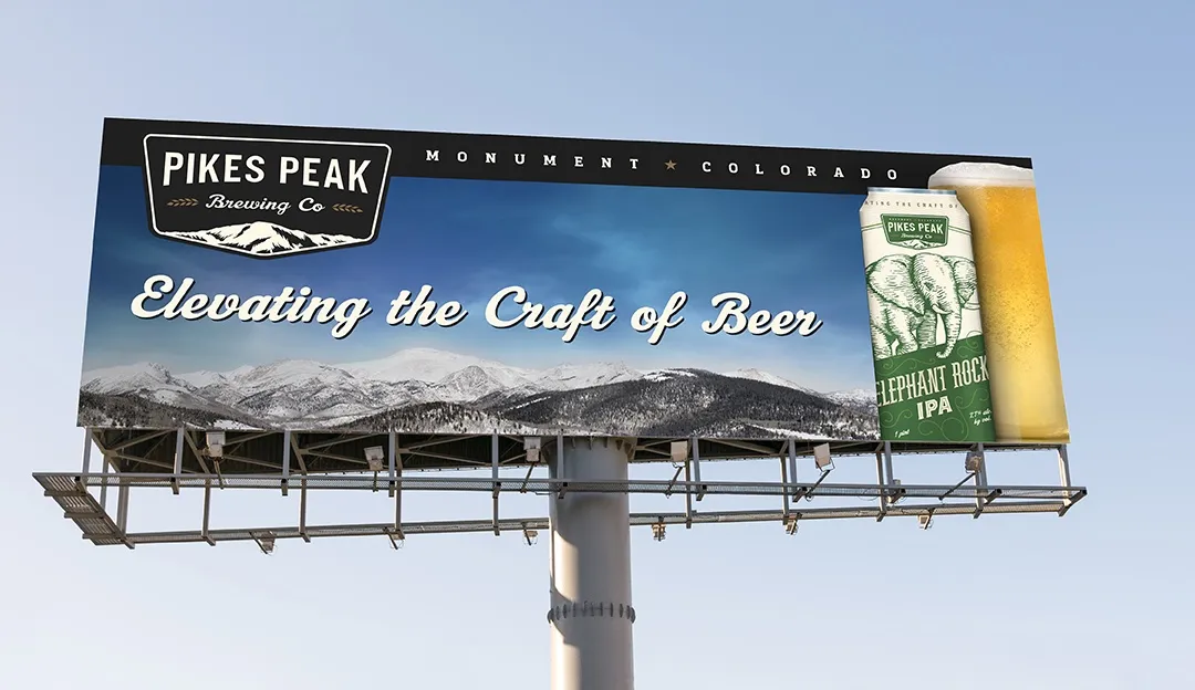 A billboard against blue sky: Elevating the Craft of Beer, with a can and a pour beside the badge