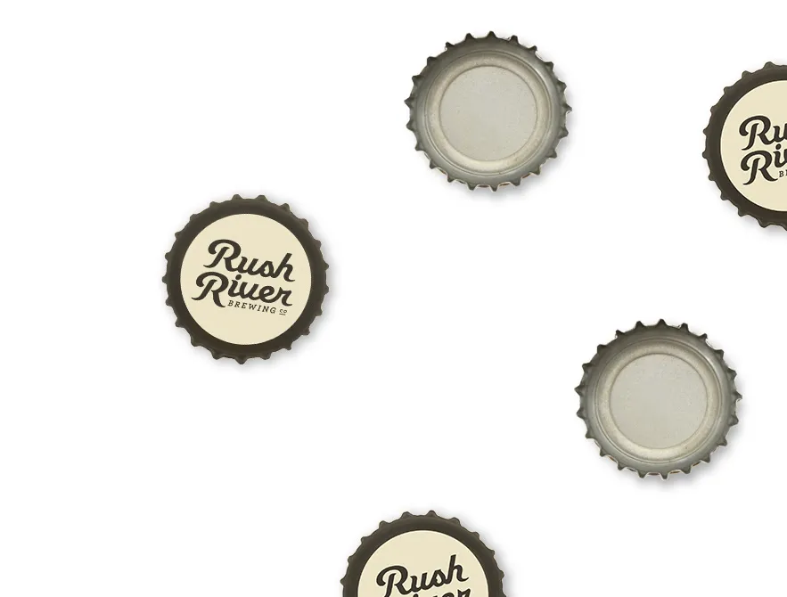 Bottle caps scattered on white, the Rush River script on each