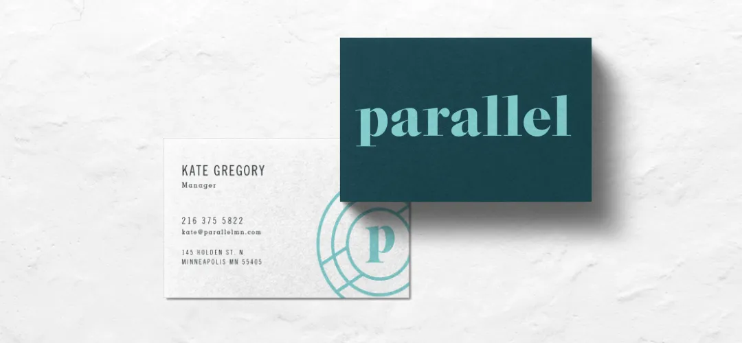 Parallel business cards, front and back, on a pale plaster surface