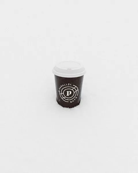A single Parallel cup, small in a field of white