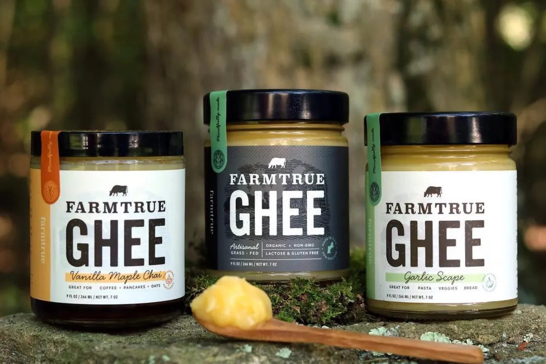 Three FarmTrue ghee jars on a log