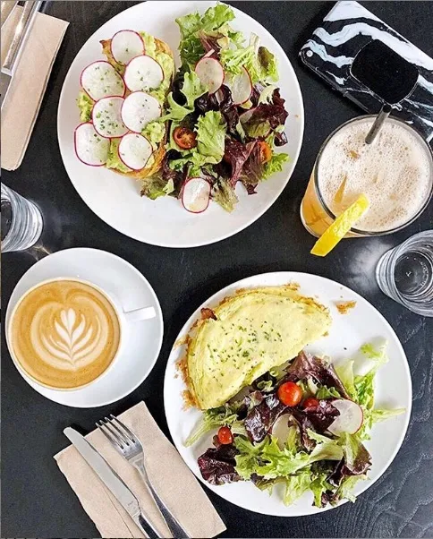 Breakfast at Parallel from above: an omelette, a salad and a latte