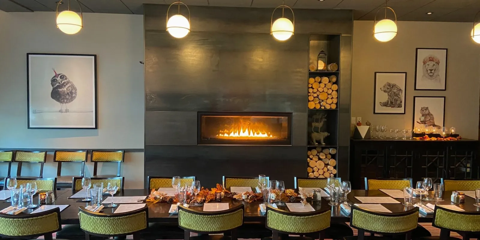 The private dining room at Hazelwood Food + Drink, a long table laid with menus and glassware in front of a linear fireplace