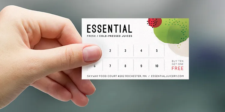 A hand holding an Essential Juicery loyalty card
