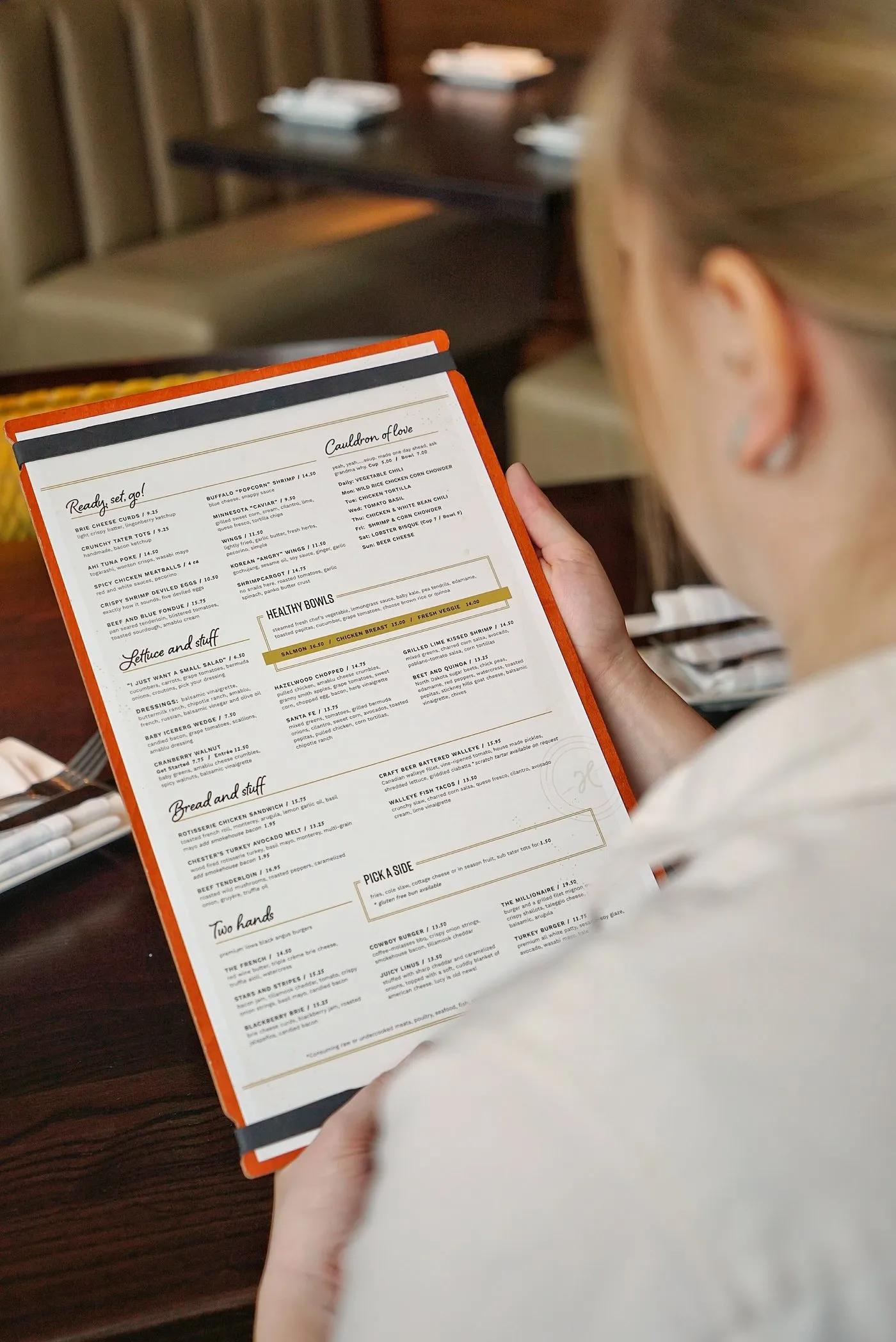 A guest reading the Hazelwood dinner menu at a booth
