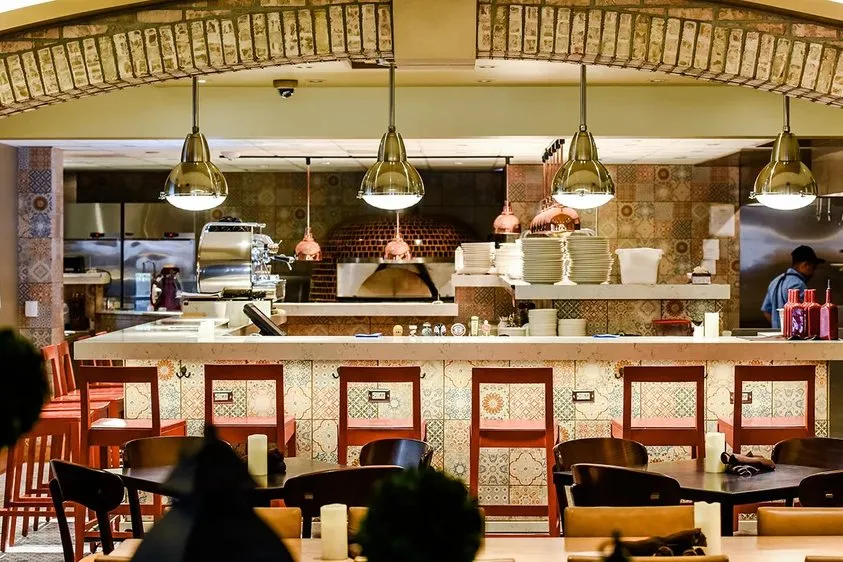 The open kitchen behind a brick counter, Terza signage above the pass