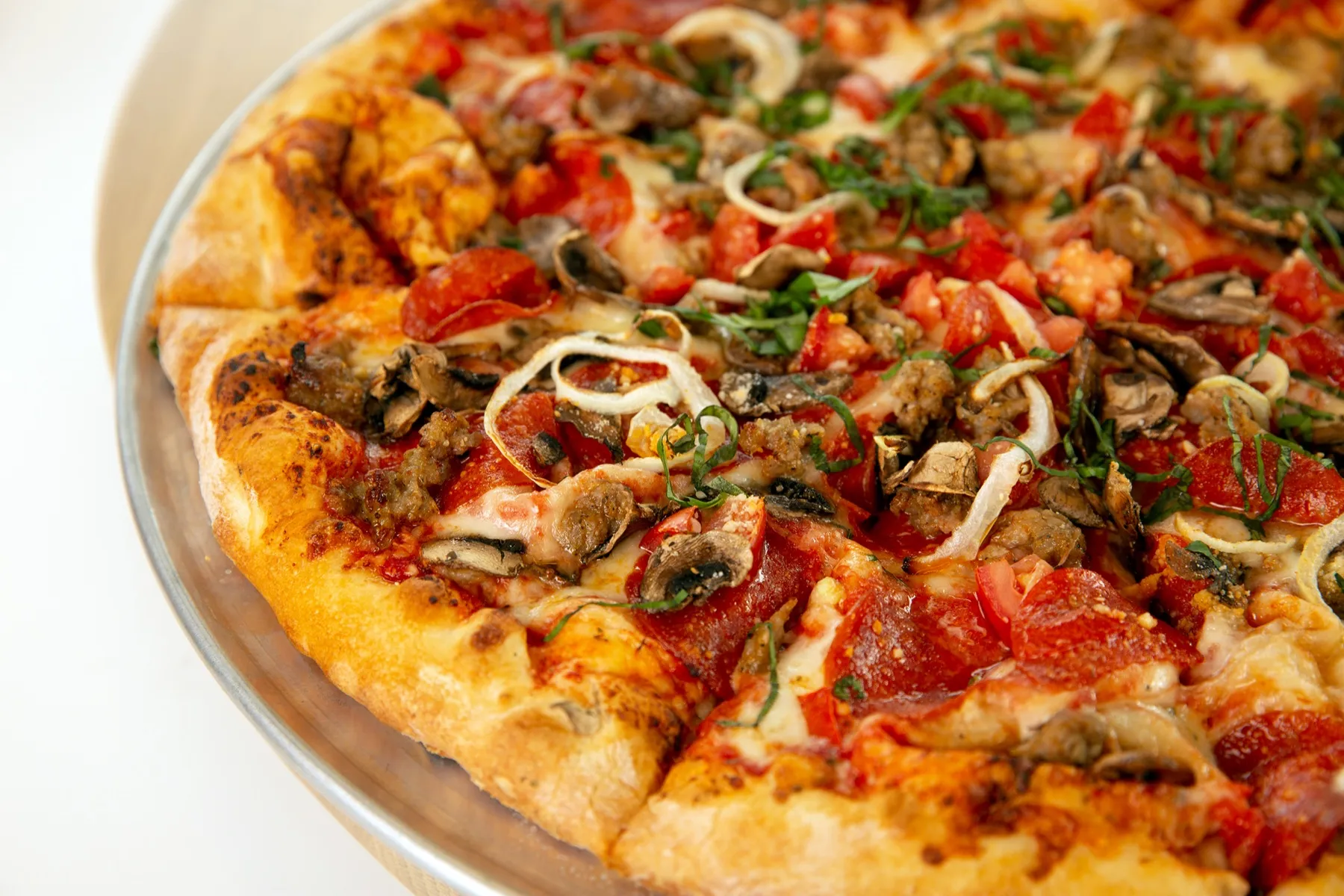 A Pizza Novara pie on a steel pan, edge blistered from the oven