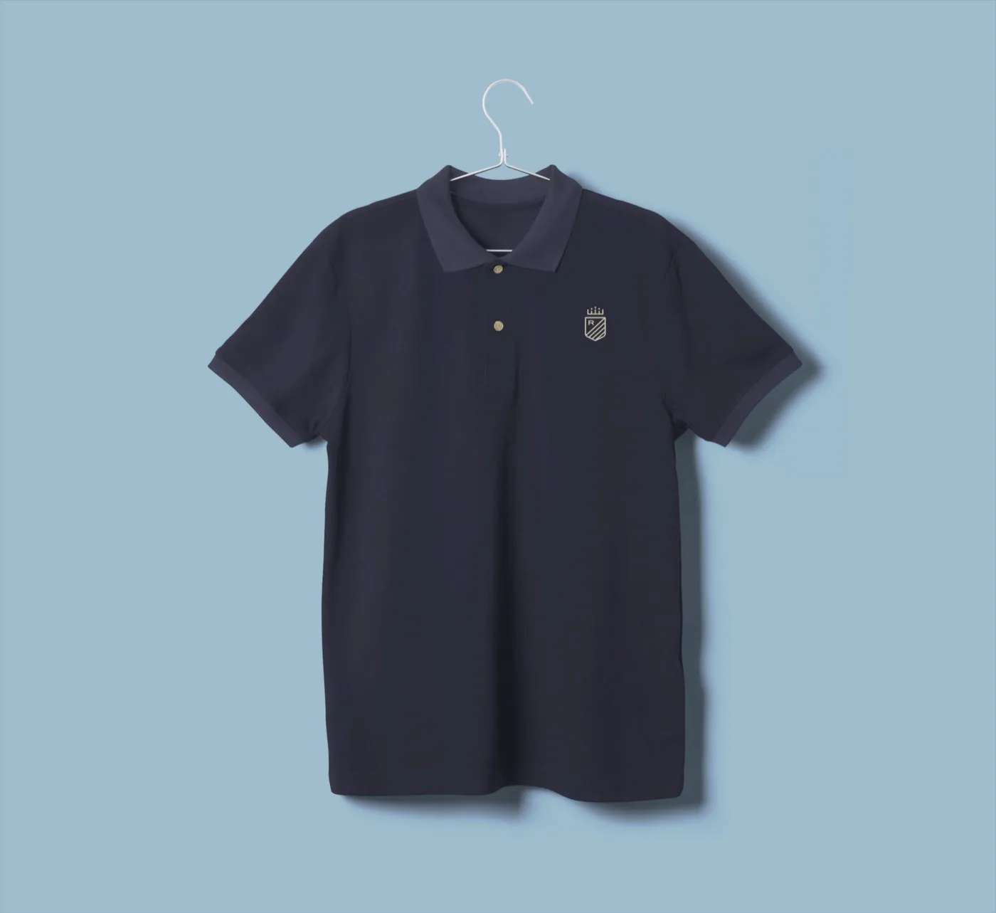 A navy polo on a hanger, the crest small on the chest