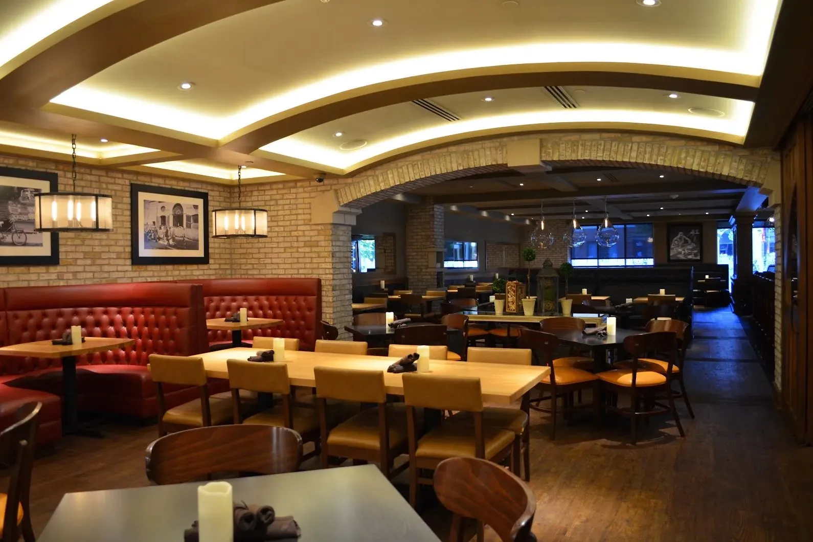 Booths and loose tables, the vaulted ceiling lit from the cove above