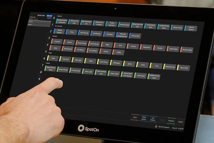 A hand on the SpotOn counter terminal, the colour-coded order screen in front of it