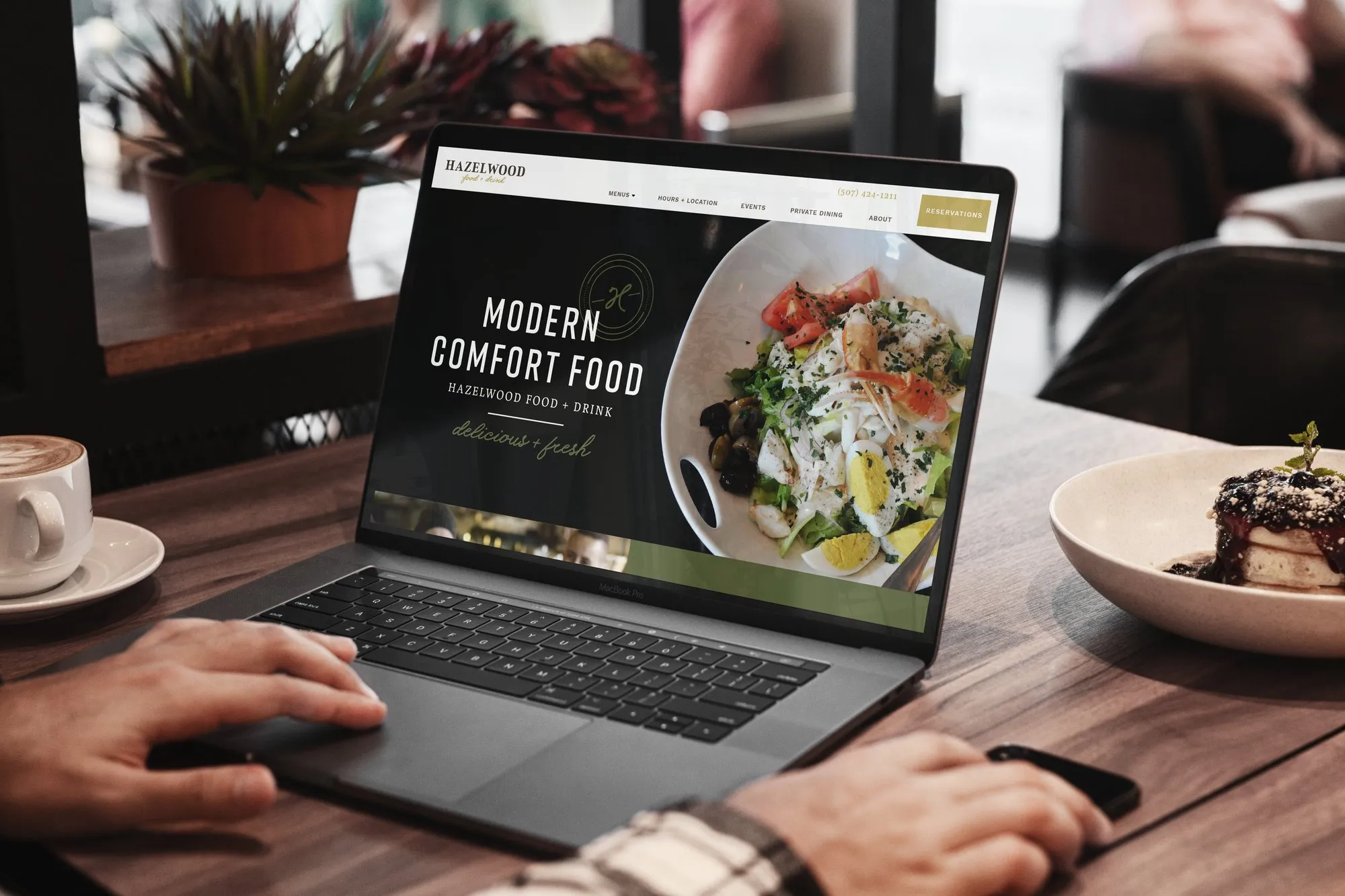 The Hazelwood website on a laptop: ‘Modern comfort food’ beside a plated salad